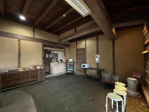 an empty room with chairs and a table and a counter at 里山グランピングむすび in Mizunami