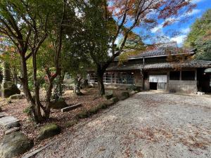 a building with a gravel driveway in front of it at 里山グランピングむすび in Mizunami