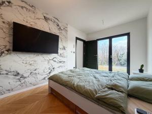 a bedroom with a large bed and a television on a wall at Villa Nella in Tinjan