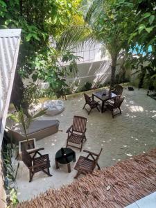 a group of wooden chairs and a table and a table sidx sidx sidx at Banana villa in Rasdhoo