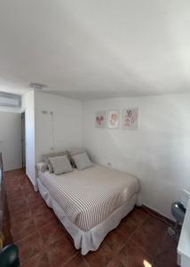 a bedroom with a bed in a white room at Estudio las lajas in Chío