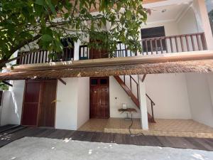a house with a staircase and a balcony at Banana villa in Rasdhoo