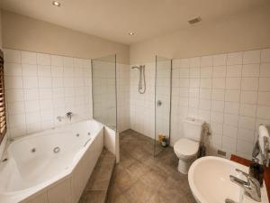 a bathroom with a tub and a toilet and a sink at Best high country retreat - Terrace Downs in Windwhistle +23 photos