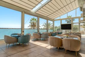 a restaurant with tables and chairs and a view of the ocean at Mövenpick Hotel & Resort Al Bida'a in Kuwait