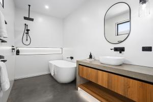 a white bathroom with a sink and a mirror at Wild Wombat in Mansfield +30 photos