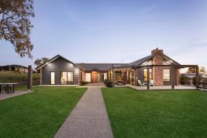 a house with a green lawn in front of it at Wild Wombat in Mansfield
