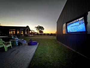 a person sitting on the grass with a tv on a building at Wild Wombat in Mansfield