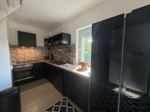 a small kitchen with black cabinets and a window at Orfű Hillside in Orfű