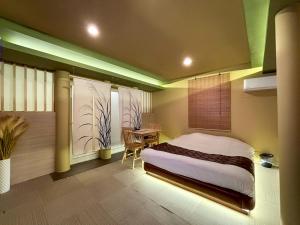 a bedroom with a bed and a table and a window at HOTEL 壮-soh-shibuya in Tokyo