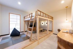 a room with a bunk bed and a desk at KITAMAE BASE Kaga Hashitate in Kaga