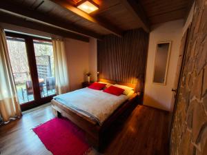 a bedroom with a bed with red pillows on it at Apartmany Janosikove diery in Terchová