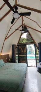 a bedroom with a bed and a ceiling fan at Lokal Hotels Dauin in Dauin +29 photos