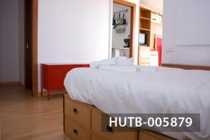 a bedroom with a bed with a white comforter at Ghat Apartments Gracia II in Barcelona