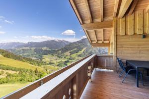 a balcony with a table and chairs and mountains at Ferienwohnung Grubgut in Taxenbach