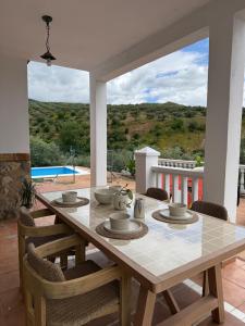 a dining room table with chairs and a large window at Casa Manila in Colmenar