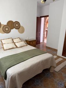 a bedroom with a large bed with hats on the wall at Casa Manila in Colmenar