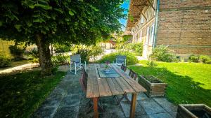 a wooden table and chairs in a yard at L'Aube du Lac in Drosnay +9 photos