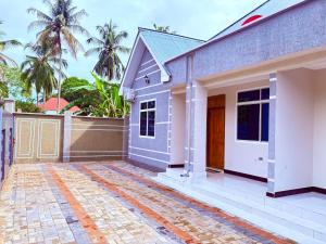 a small house with a brick driveway at Zanzibar Apartment 1 in Kibele