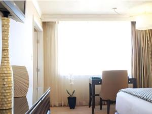 a bedroom with a bed and a desk in a room at Harrahs Hotel Reno in Reno