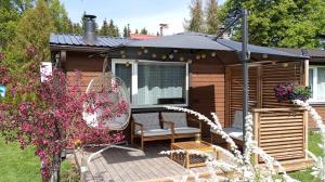 a cabin with an umbrella and a chair on a deck at Taali Hoovimaja in Jaakna