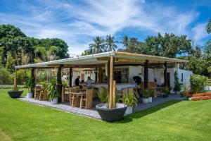 a restaurant with a pavilion in a garden at Lokal Hotels Dauin in Dauin