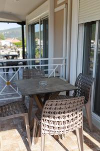 a wooden table and chairs on a porch at Studios Denis in Stavros