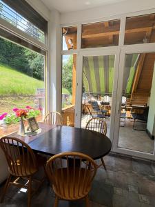 a dining room with a table and chairs and a patio at Apartma Arja in Spodnje Gorje