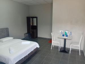 a bedroom with a bed and a table and chairs at GP StayIn in Lunas +3 photos