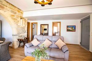 a living room with a couch and a stone wall at Traounou Serenity Villa Near to Afandou Beach in Afantou