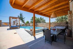 a patio with a table and a swimming pool at Traounou Serenity Villa Near to Afandou Beach in Afantou