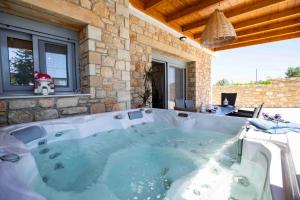 a jacuzzi tub in a stone building with at Traounou Serenity Villa Near to Afandou Beach in Afantou