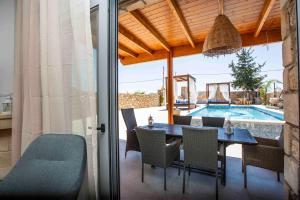 a dining room with a table and chairs and a pool at Traounou Serenity Villa Near to Afandou Beach in Afantou