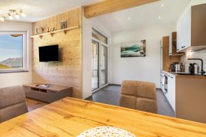 a kitchen and living room with a wooden table and chairs at Ferienwohnung Grubgut in Taxenbach