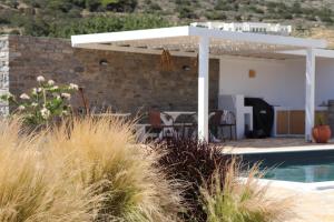 a white pergola next to a swimming pool at Villa Kairos in Angairiá