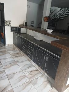 a kitchen with a black counter and a tile floor at Villa Ross in Saly Portudal +5 photos