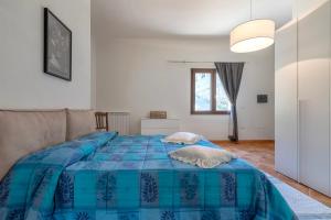 a bedroom with a bed with a blue comforter at Casa Orizzonte Anglona in Nulvi