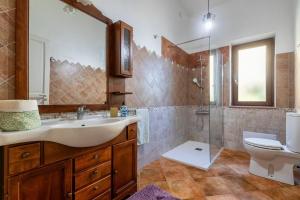 a bathroom with a sink and a shower and a toilet at Casa Orizzonte Anglona in Nulvi +24 photos