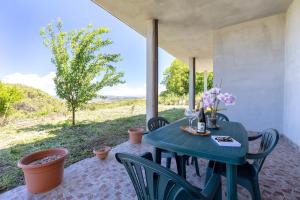 a blue table with chairs and flowers on a patio at Casa Orizzonte Anglona in Nulvi