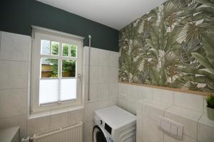 a bathroom with a washing machine and a window at FeWo Gisa - Graal Müritz in Graal-Müritz