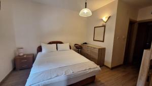a bedroom with a large white bed and a lamp at Villa Alla Bed and Breakfast in Herceg-Novi