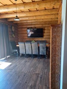 a dining room with a table and chairs and a television at Zrub Živa in Krupina