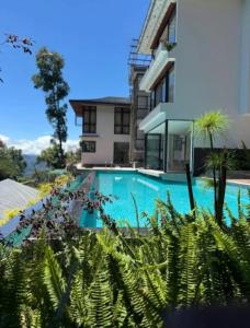 a swimming pool in front of a house at The Yasa Hotel In Gangtok in Gangtok