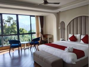 a hotel room with a bed and a table and chairs at The Yasa Hotel In Gangtok in Gangtok