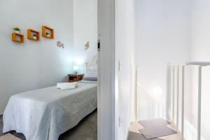 a white bedroom with a bed and a window at Villa Angela in Nulvi