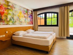 a bedroom with a bed with a painting on the wall at Family Hotel Schloss Rosenegg in Fieberbrunn +70 photos