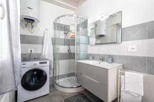 a bathroom with a washing machine and a washer at Villa Angela in Nulvi +28 photos