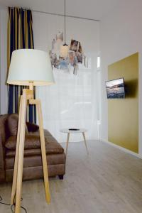 a room with a couch and a lamp and a table at URBAN STAY Hamburg - Apartments "BACKBORD" & "STEUERBORD" in Hamburg