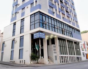 a tall blue and white building on a street at Caravelle Palace Hotel in Curitiba