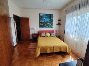 a bedroom with a bed with a yellow bedspread at Yellow House in Senhora da Hora