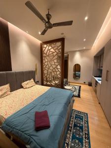 a bedroom with a bed and a ceiling fan at THE MOONLIGHT STUDIo in Ghaziabad